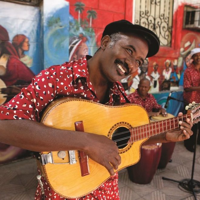 Cubansk musiker spiller gitar i Havanna – symbol på ekte kultur, musikk og reise til Cuba